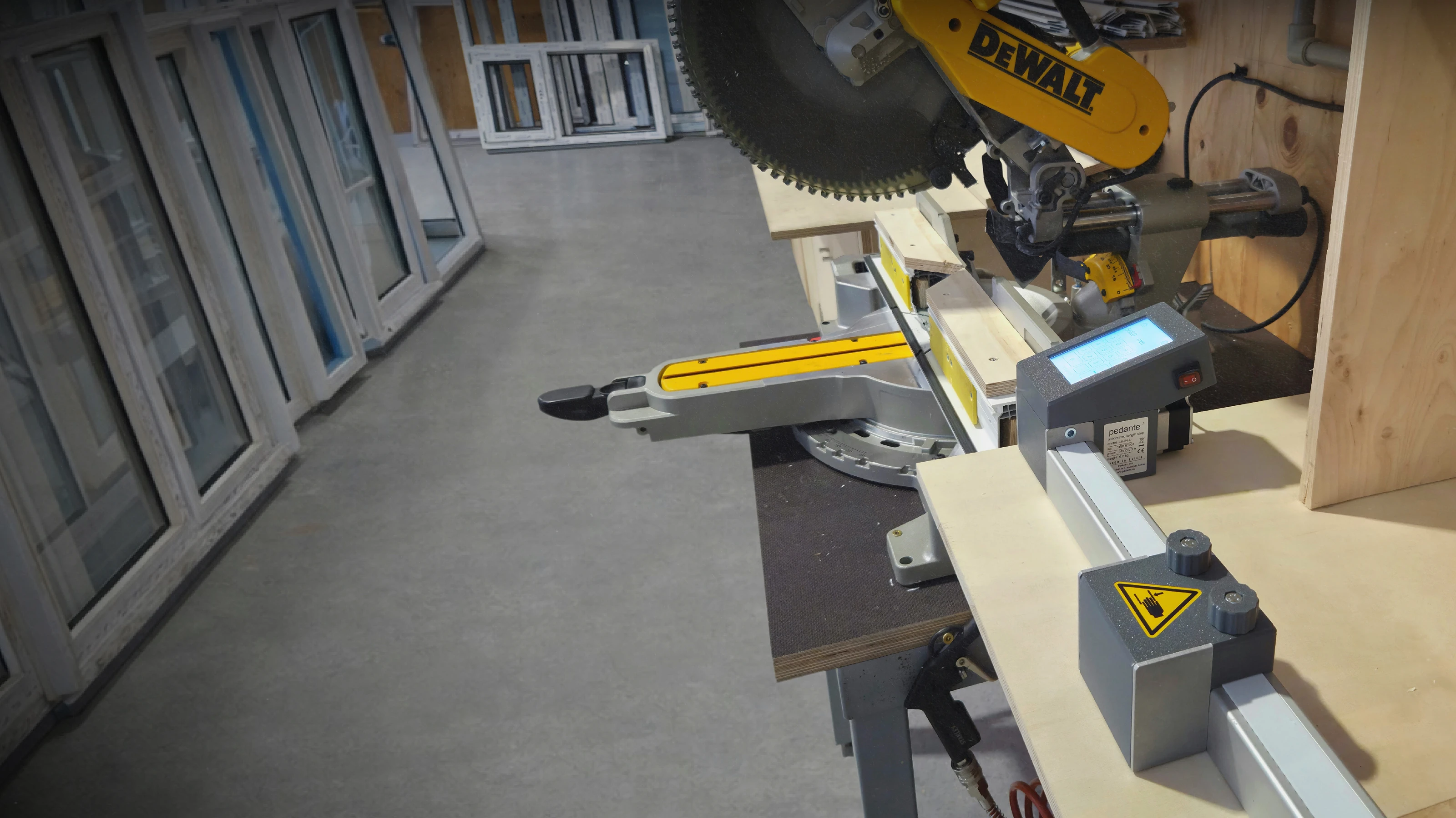 Butée de longueur automatique pour scie Pedante montée sur une station de sciage dans un atelier de fabrication de fenêtres